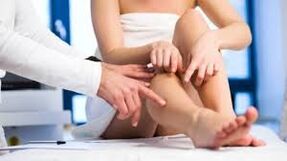 O médico examina a perna do paciente
